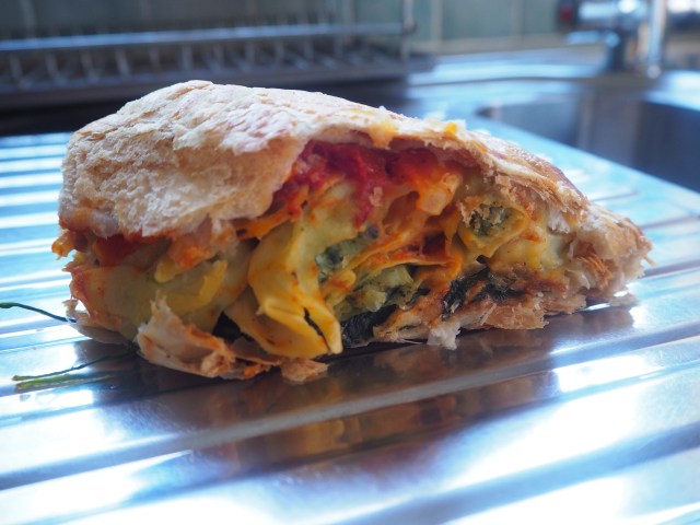 Tortellini pie (pasta in a white sauce, layered with tomato sauce and spinach)