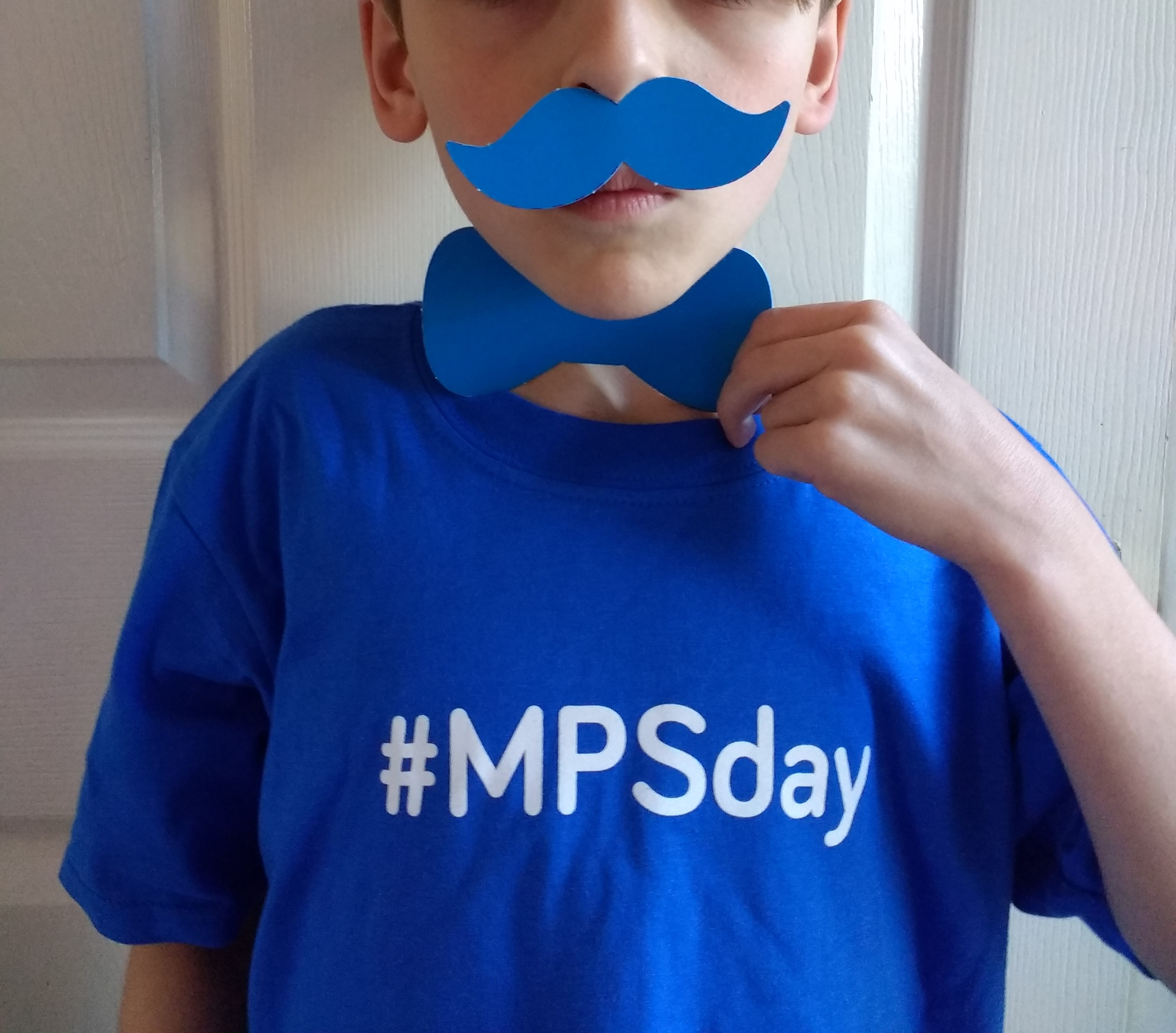 Boy wearing #MPSday t-shirt with a blue paper bow-tie and moustache