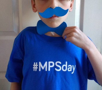 Boy wearing #MPSday t-shirt with a blue paper bow-tie and moustache