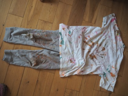 A tie-dyed T-shirt and some trousers covered in face-paint